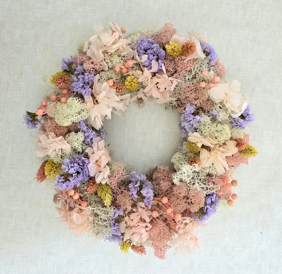 Blumenkranz mit Pastellblumen auf Stoff.