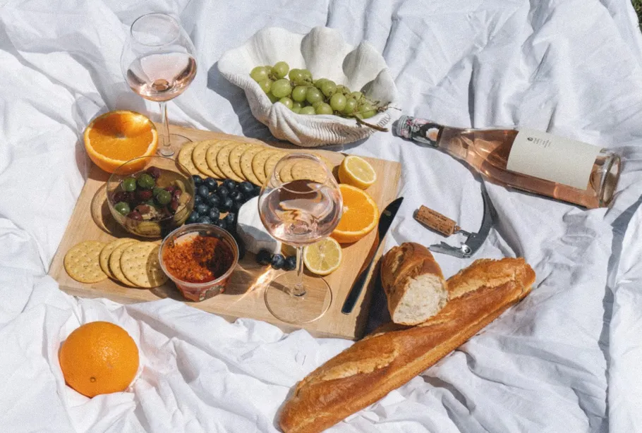 Picknick mit Wein, Brot, Obst und Käse.