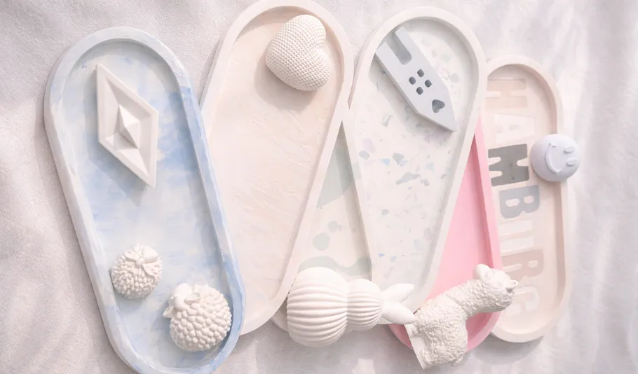 Keramikteller mit dekorativen weißen Objekten.