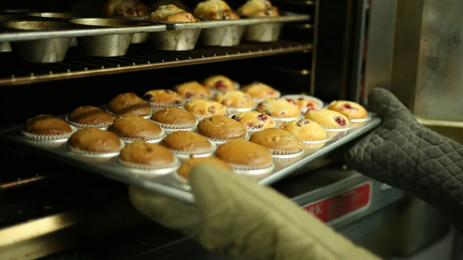Muffins being removed from hot oven.