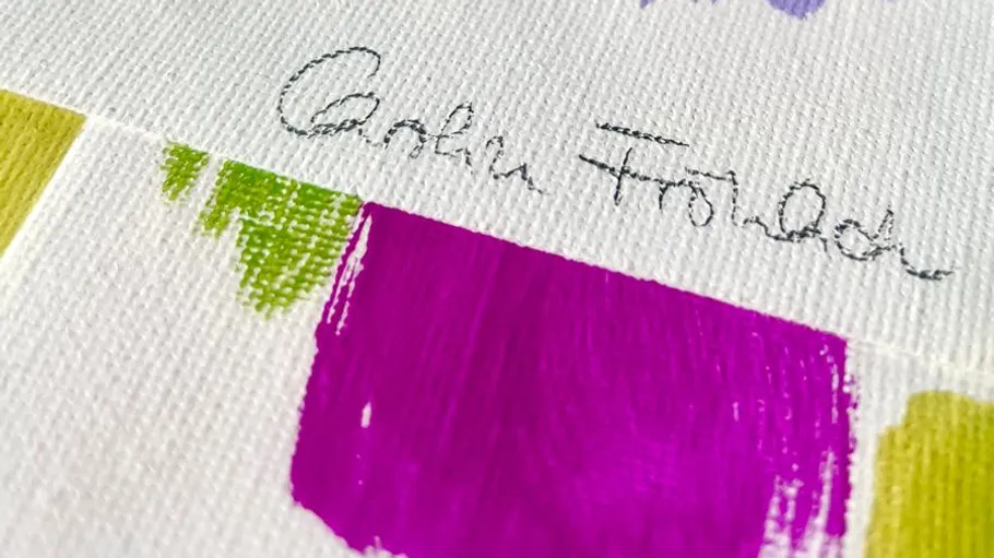 Signature with colorful paint swatches on canvas.