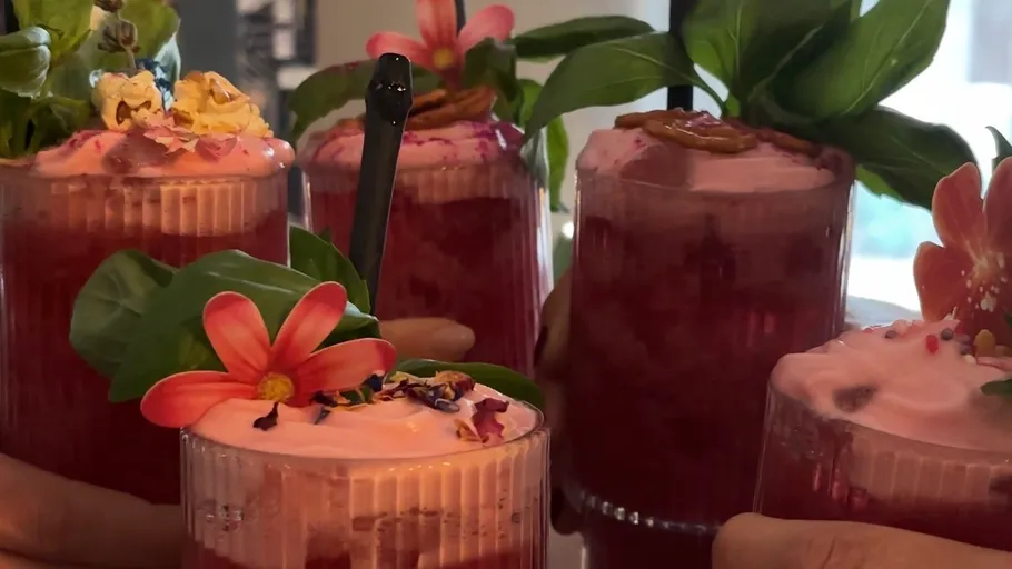 Bunte Getränke mit Blumen- und Blätterdeko.