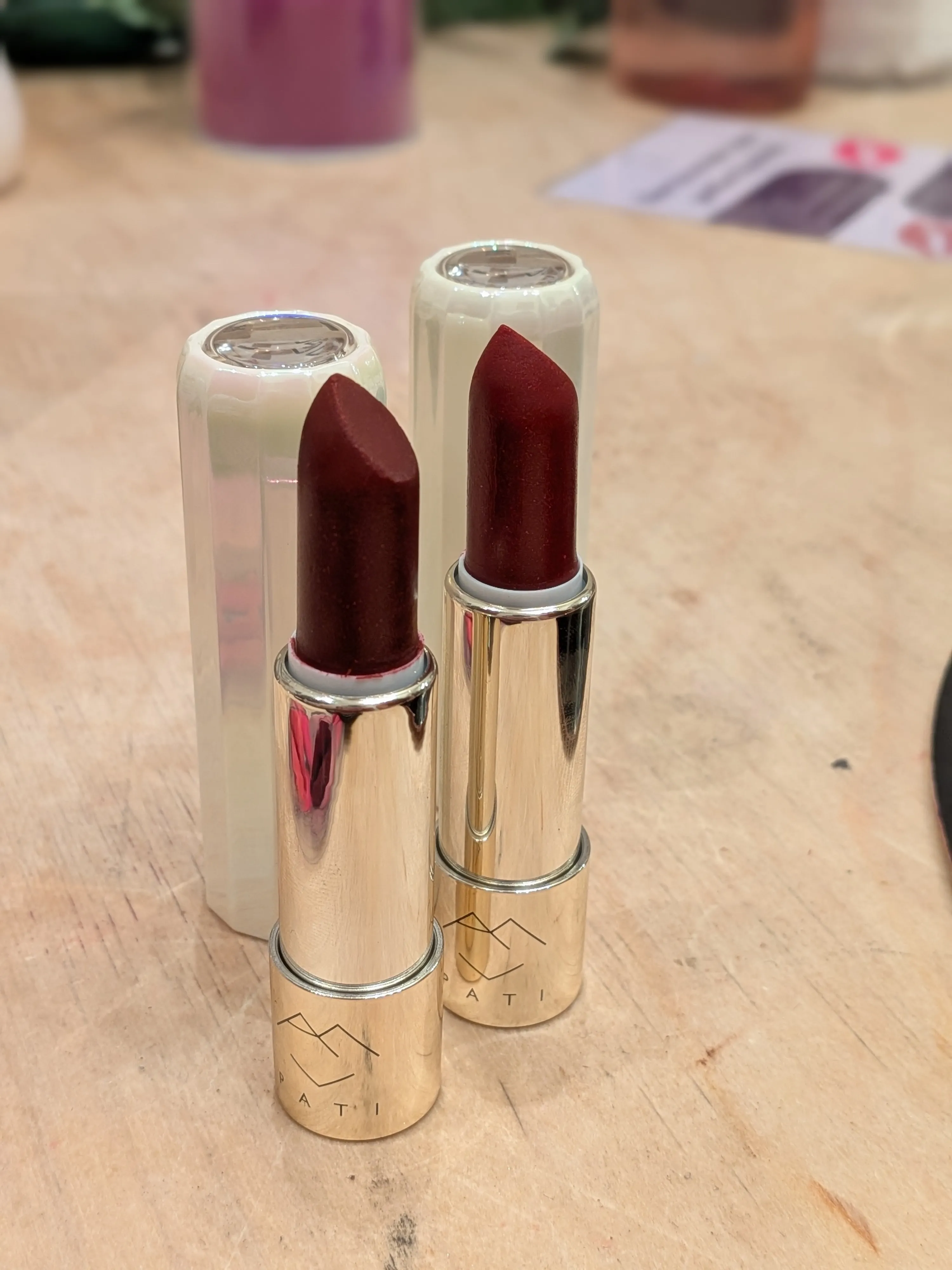 Zwei rote Lippenstifte auf einem Holztisch.