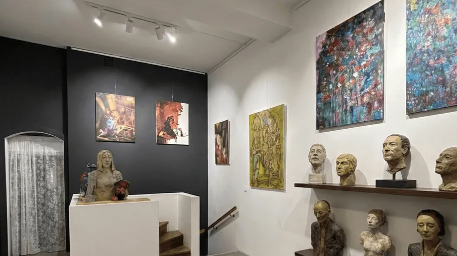 Art gallery with sculptures and paintings displayed.