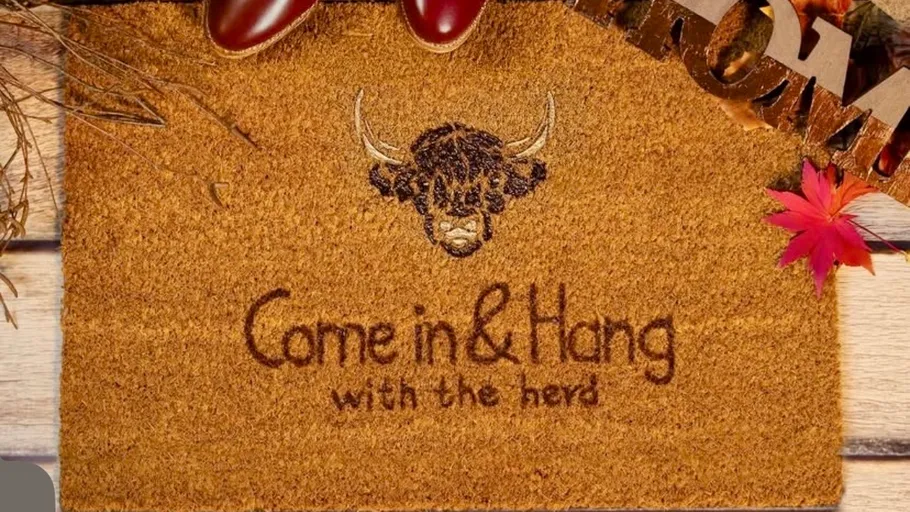 Doormat with buffalo design on wooden floor.