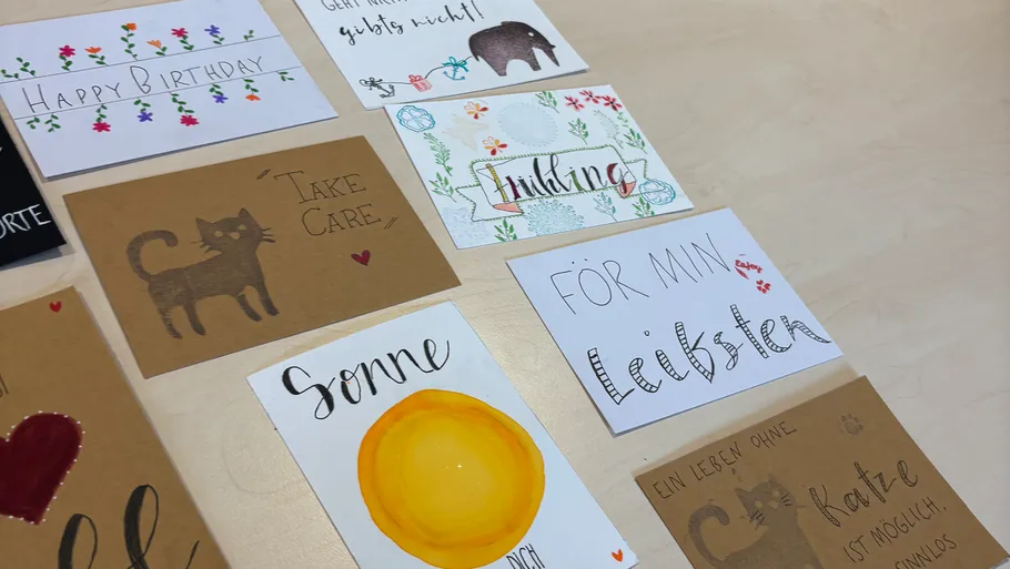 Handcrafted greeting cards on wooden table displayed.