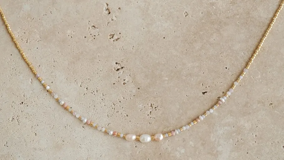 Delicate beaded necklace on marble surface.