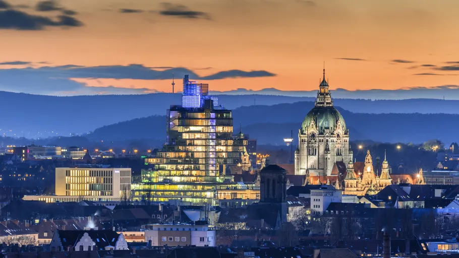Cityscape with illuminated buildings at sunset.