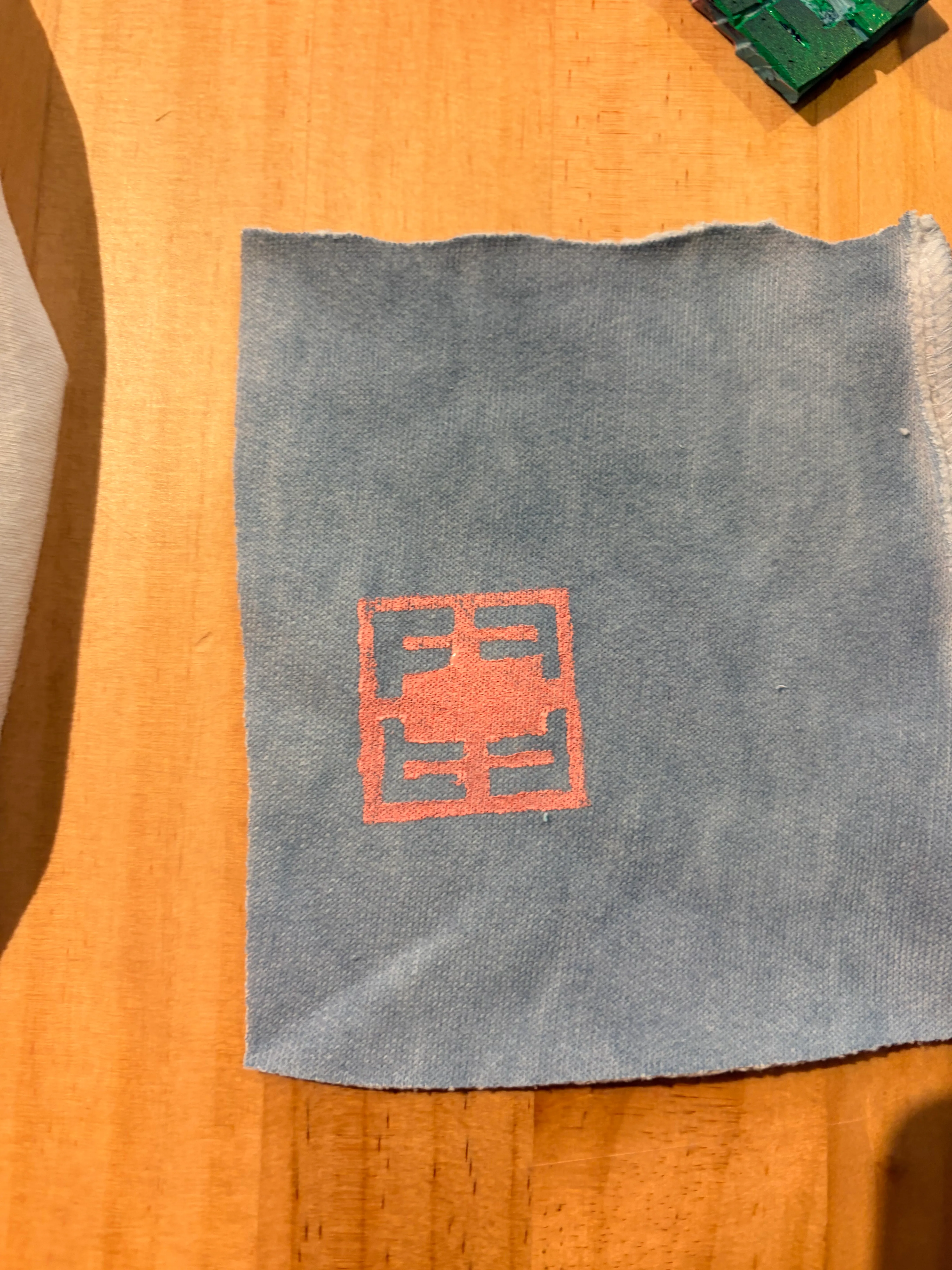 Blauer Stoff mit rotem Stempel auf Tisch.