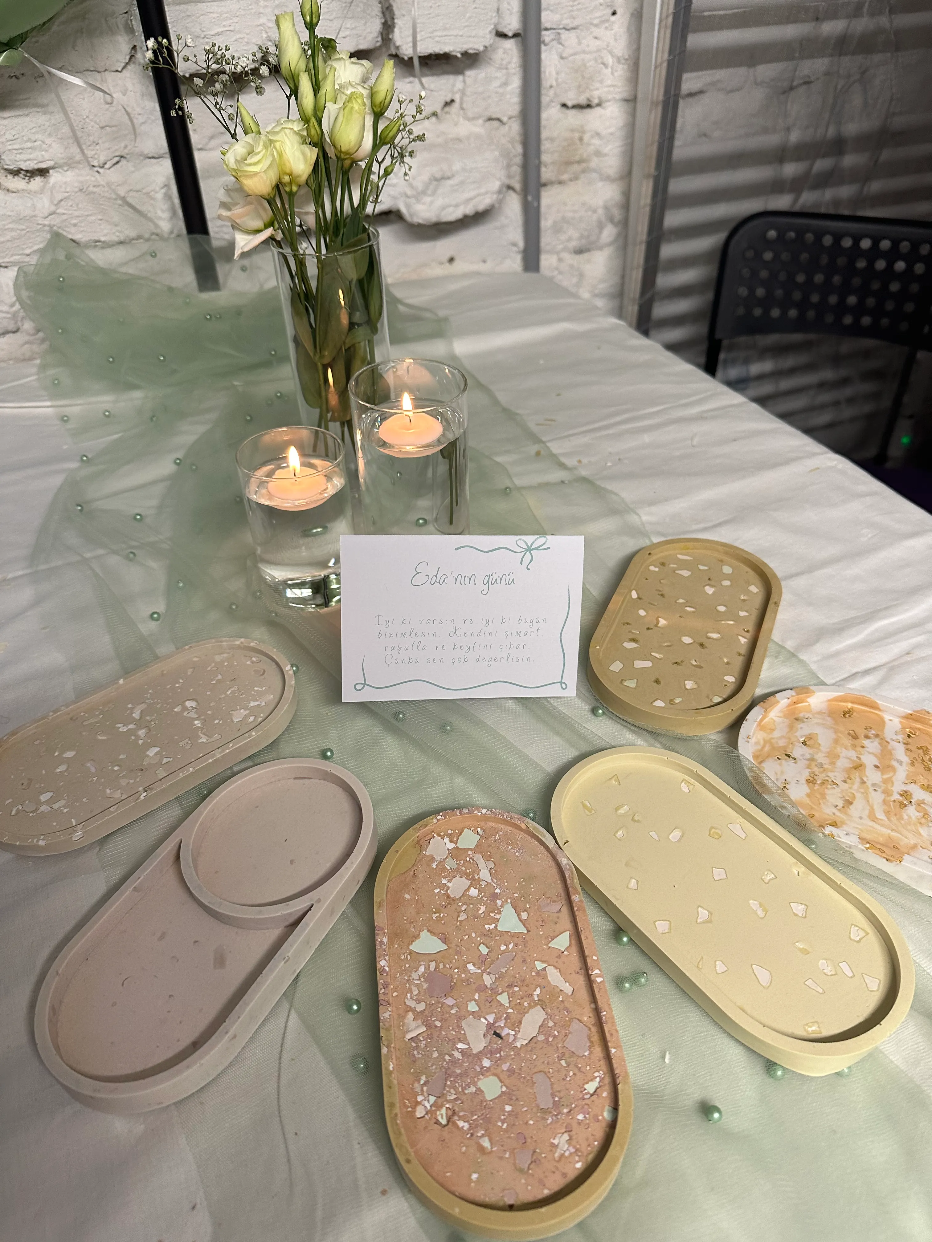 Dekorative Tabletts auf Tisch mit Kerzen und Blumen.