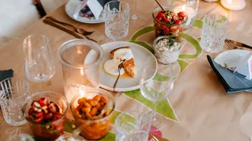 Tisch mit Essen und Kerzen, gedeckt zum Essen.