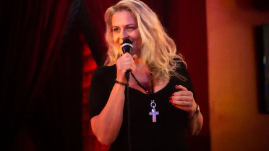 Woman singing with microphone on stage.