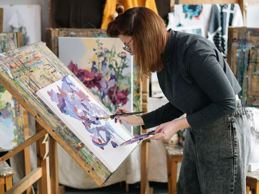 Artist paints on canvas in a studio.