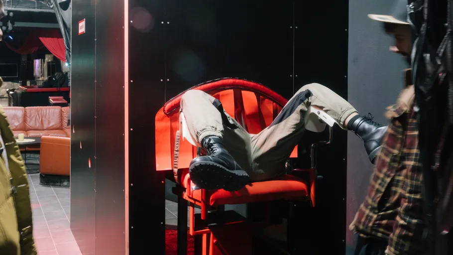 Person sitting backward on red chair indoors.
