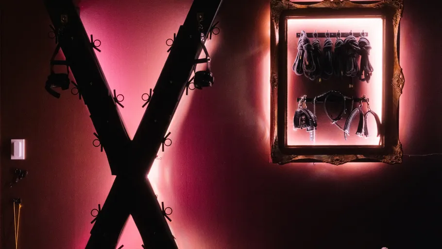 Illuminated X-frame with accessories in dark room.