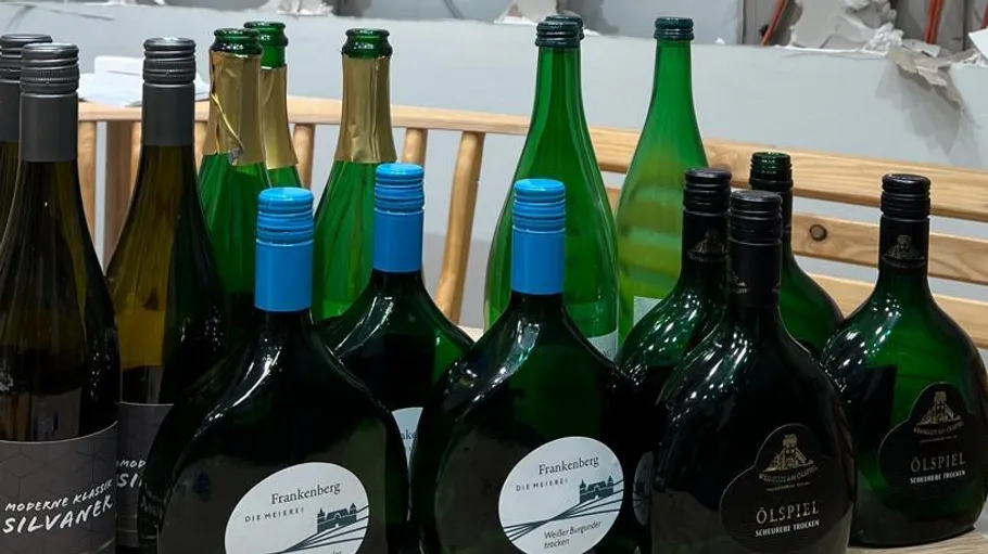 Assorted wine bottles on wooden table.