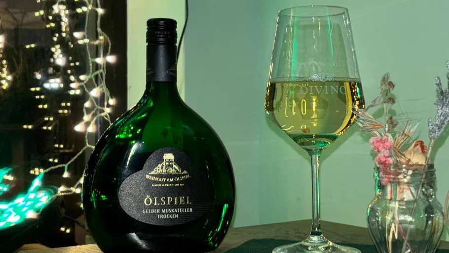 Wine bottle and glass on table with lights.