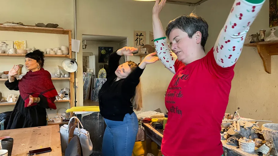 Drei Frauen dehnen sich in einem Kunststudio.