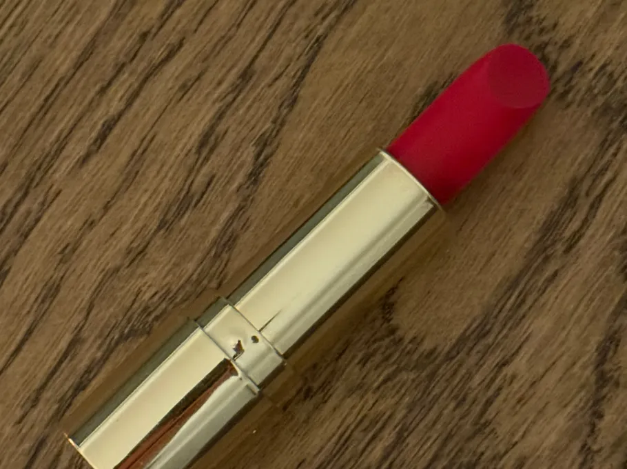 Roter Lippenstift auf Holzoberfläche.