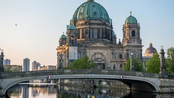 Cathedral with domes, river, and bridge.