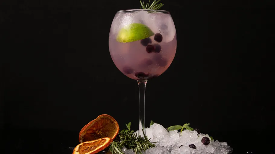 Cocktail with berries and lime on ice.