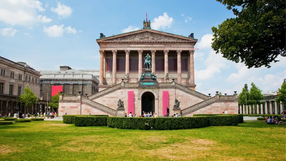 Historisches Museumsgebäude mit Treppen und Statue, draußen.