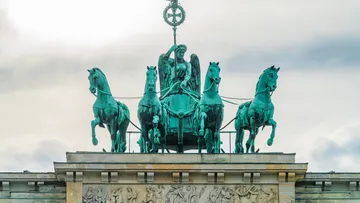 Quadriga auf dem Brandenburger Tor vor bewölktem Himmel.