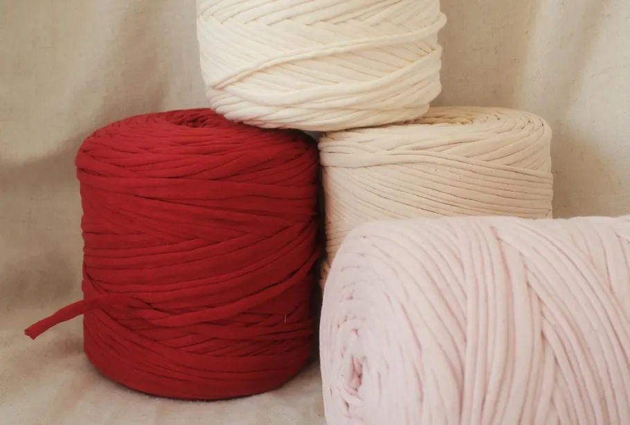 Four yarn spools in red and neutral colors.