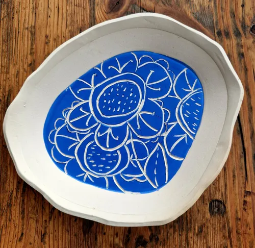 Dekorativer Teller mit blauem Blumendesign.