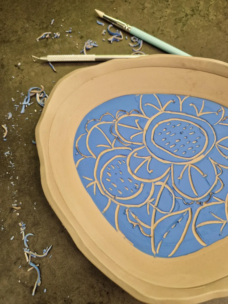 Tonplatte mit geschnitztem Blumendesign.