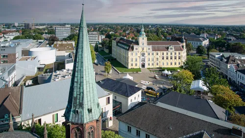 Church spire in cityscape with historical building.