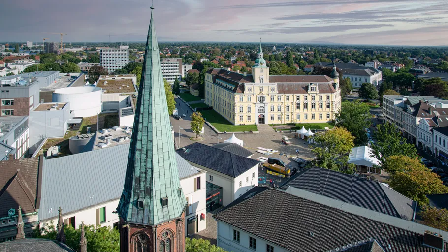 Church spire in cityscape with historical building.