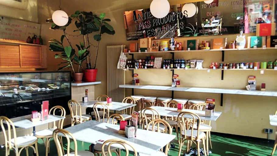 Gemütliches Café mit Holzstühlen und Regalen.