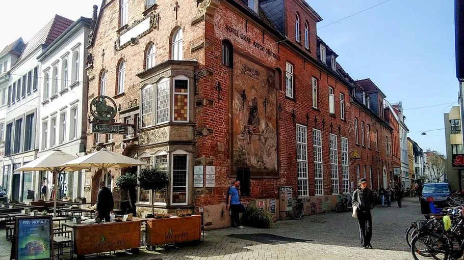 Historic brick building with street cafes.