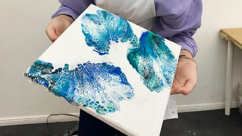 Person hält Acryl-Fließkunstwerk.