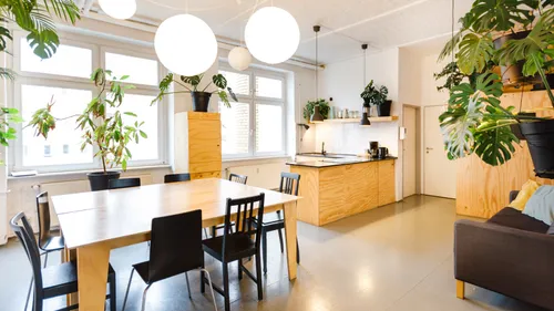 Modern kitchen and dining area with plants.