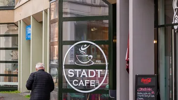 Mann geht an einem Café-Eingang vorbei.