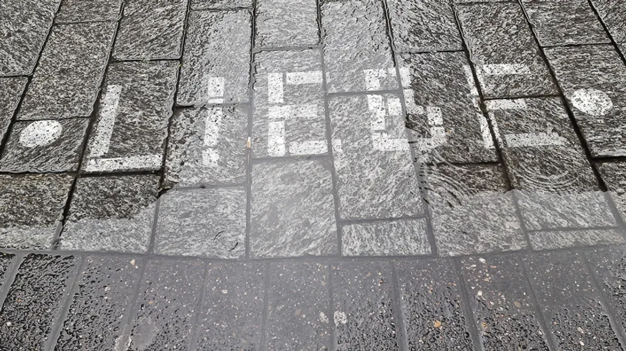 The word 'LIEBE' painted on wet cobblestones.