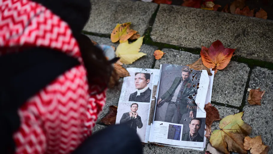 Open magazine with photos on sidewalk.