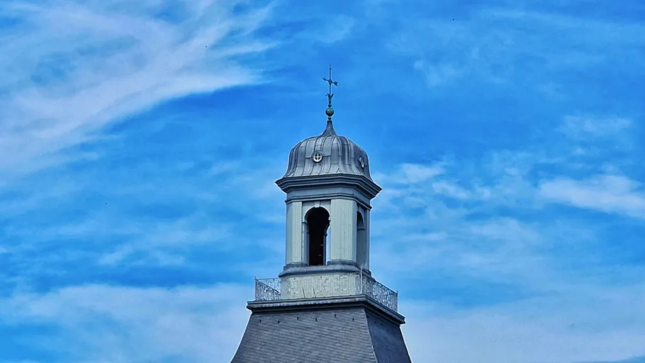 Kuppel auf Gebäude vor blauem Himmel.