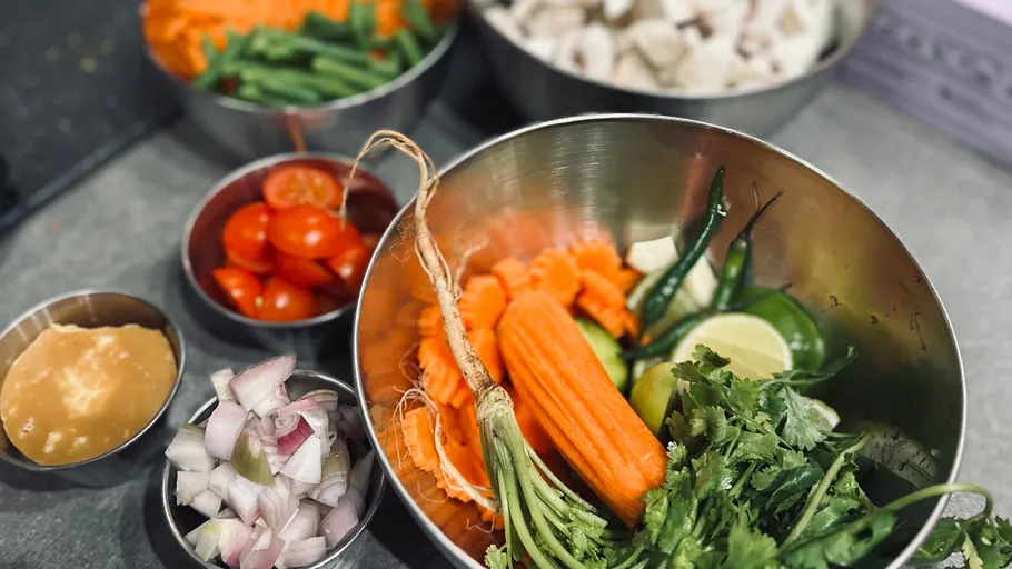 Various chopped vegetables in metal bowls.