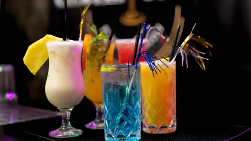 Bunte Cocktails mit Garnierungen auf Bar.
