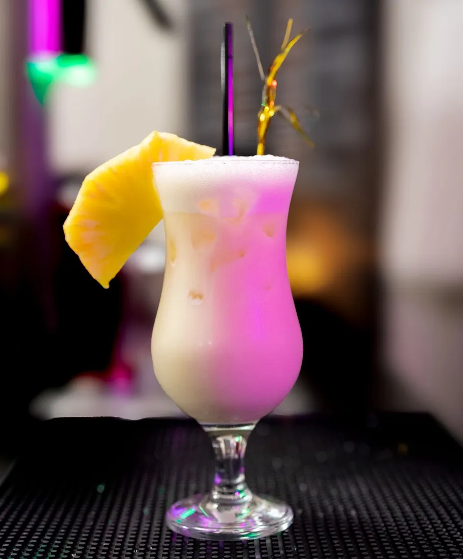 Cocktail with pineapple slice in a bar.