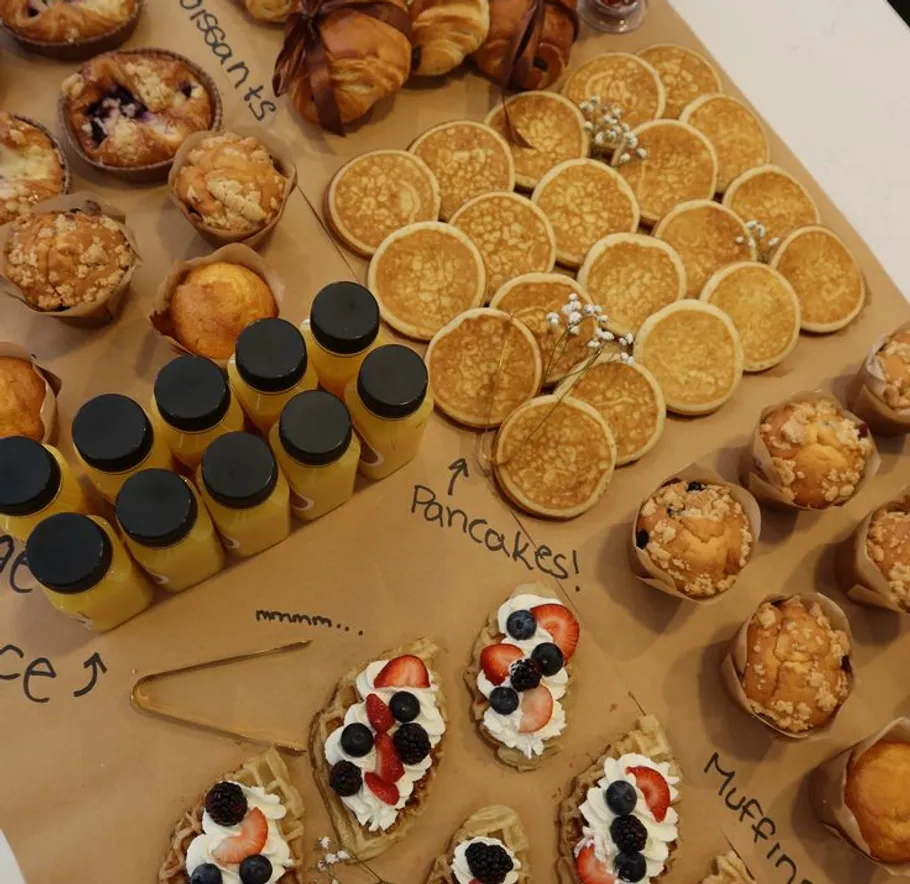 Assorted breakfast pastries and juices on table.