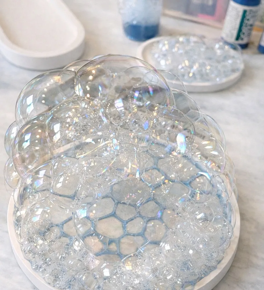 Soap bubbles sitting on a white plate.