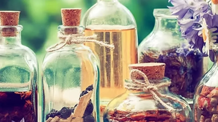 Glass bottles with herbs outdoors.