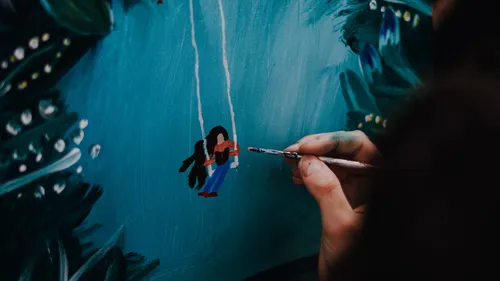 Person painting small figure on canvas.