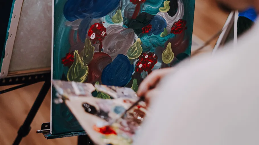 Person painting abstract artwork on easel.