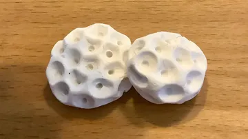 Ölflasche über porösen weißen Scheiben auf Holz.