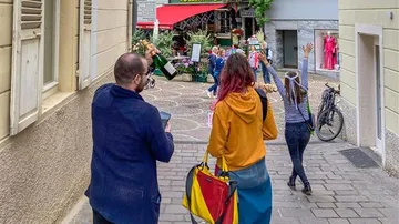 Three people walking joyfully in a city street.